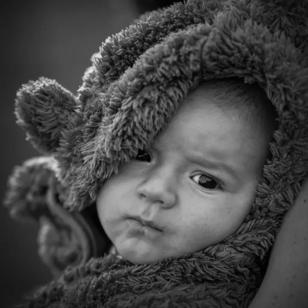 Černob&iacute;l&yacute; portr&eacute;t novorozence v huňat&eacute;m overalu s medvěd&iacute;mi ou&scaron;ky &mdash; newborn focen&iacute; Praha.