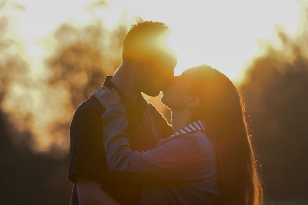 Silueta p&aacute;ru při polibku proti z&aacute;padu slunce - p&aacute;rov&eacute; focen&iacute;.