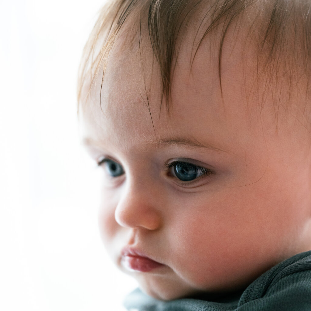 Portr&eacute;t batolete s modr&yacute;ma očima a zamy&scaron;len&yacute;m pohledem.