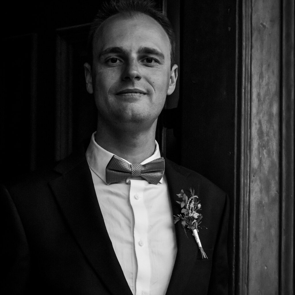 Portr&eacute;t ženicha ve dveř&iacute;ch s mot&yacute;lkem a kors&aacute;ž&iacute;.